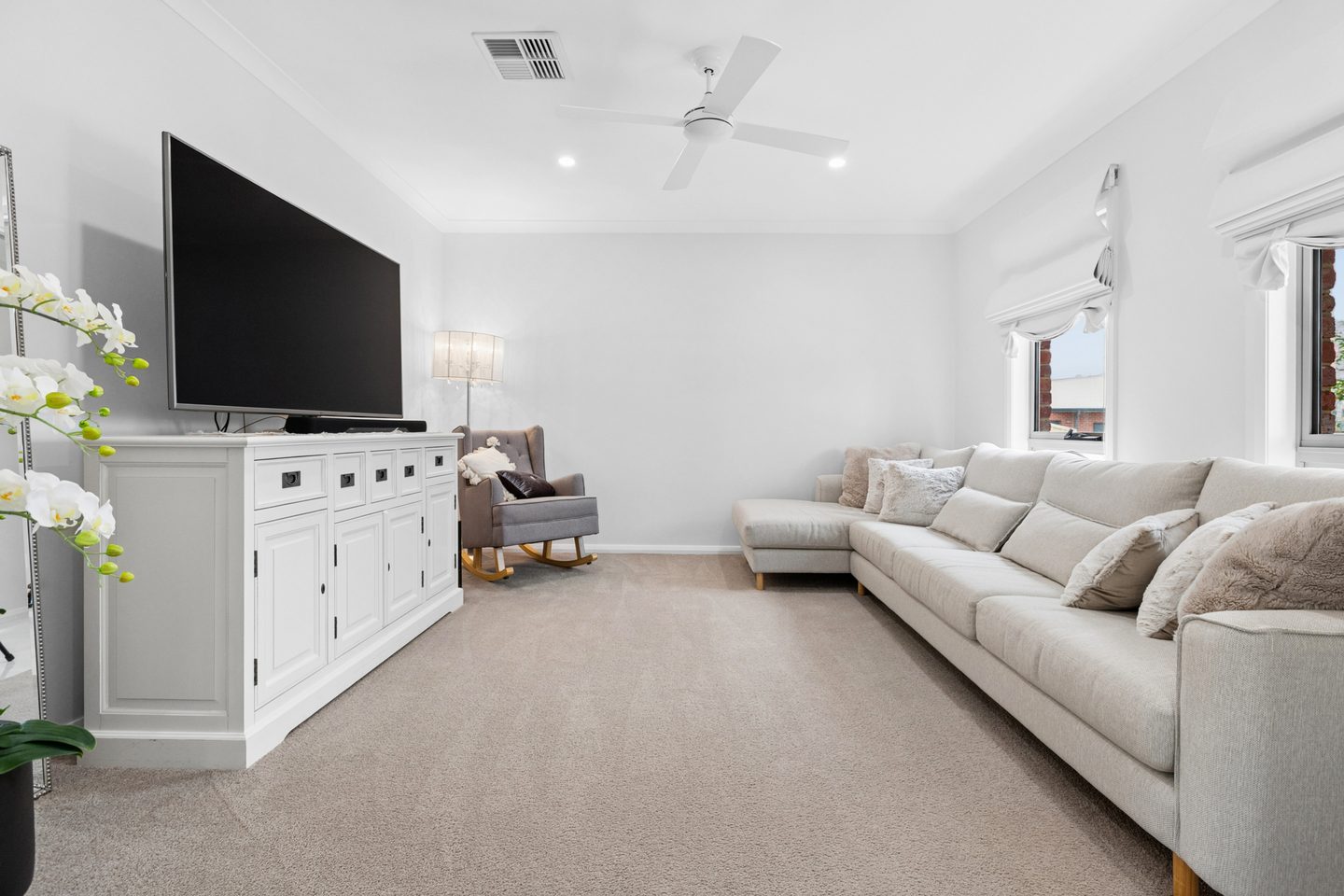 Separate front lounge with carpet, wide windows and a ceiling fan