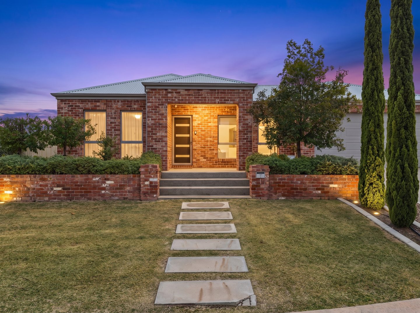 The front garden path and illuminated brick entrance in the evening